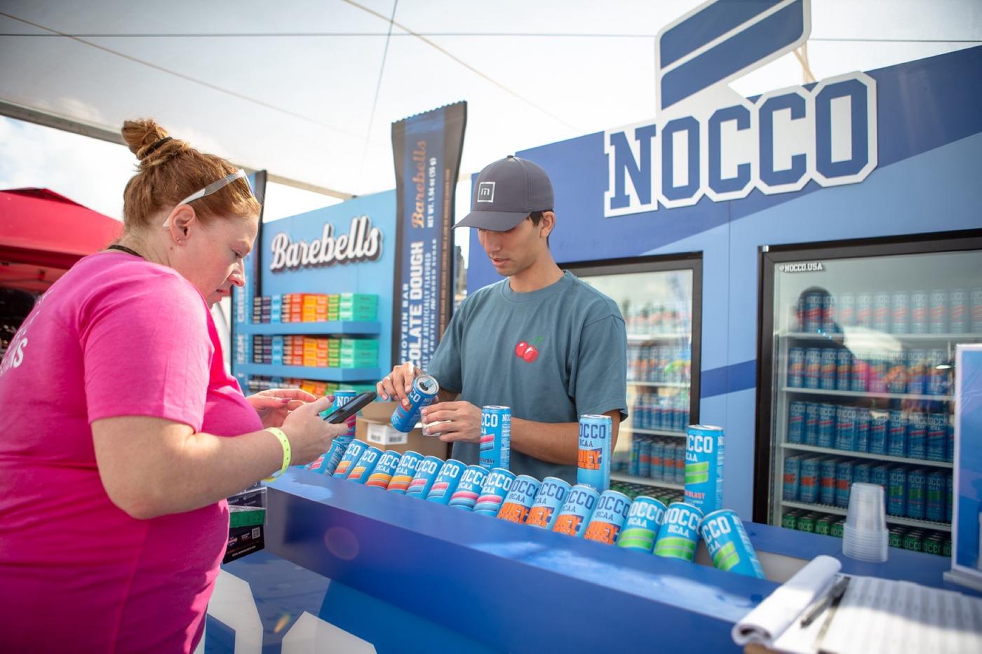 Attendee sampling drinks at a booth