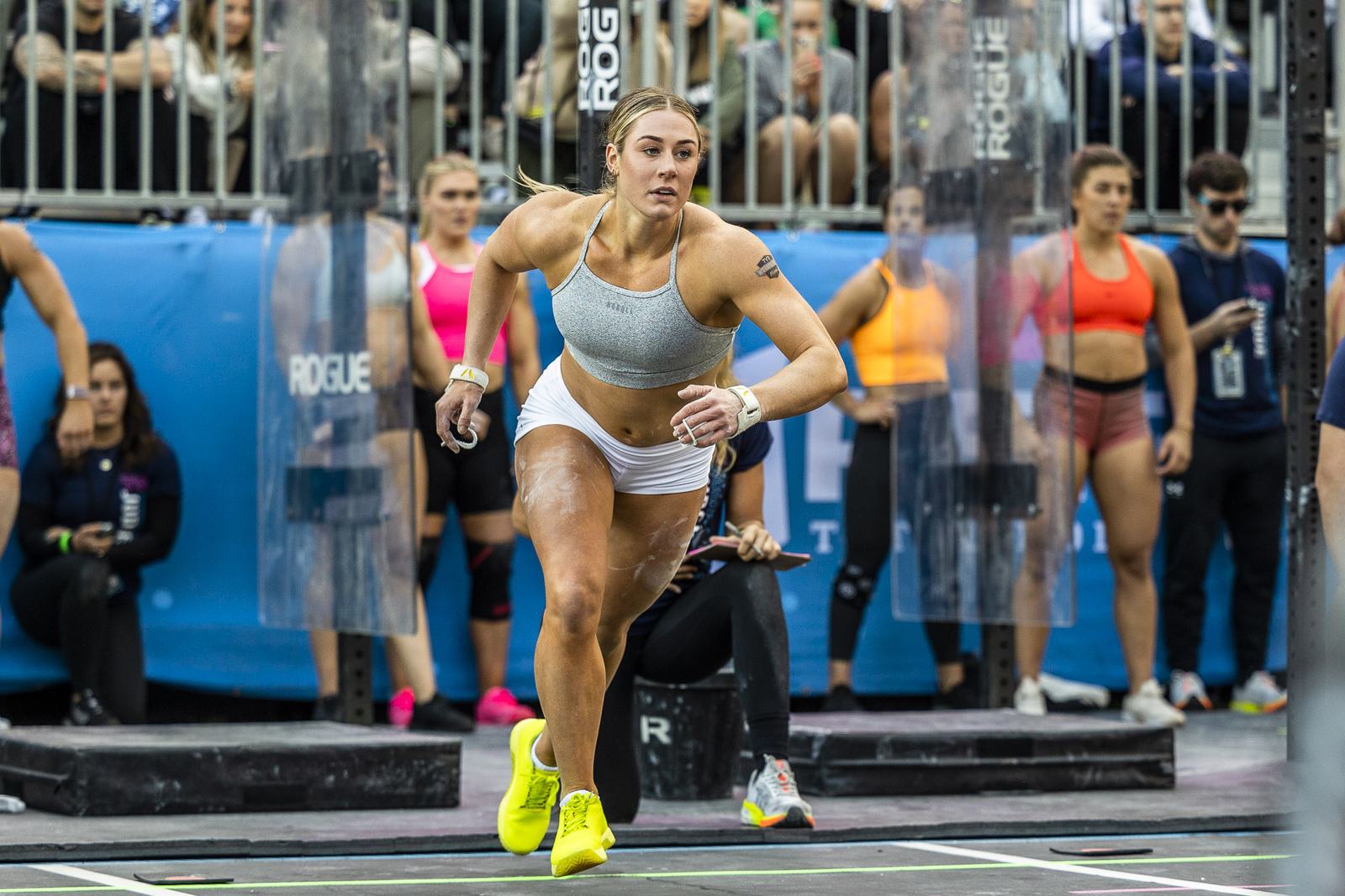 Elite athlete sprinting off the start line in front of a packed crowd