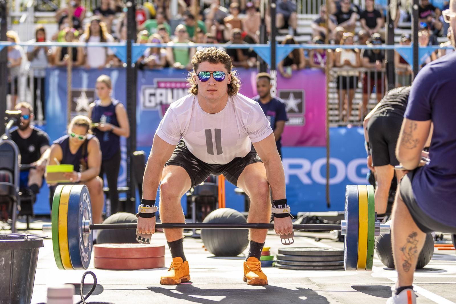 Athlete setting up a barbell lift in front of the Gauntlet and U.S. Army banner