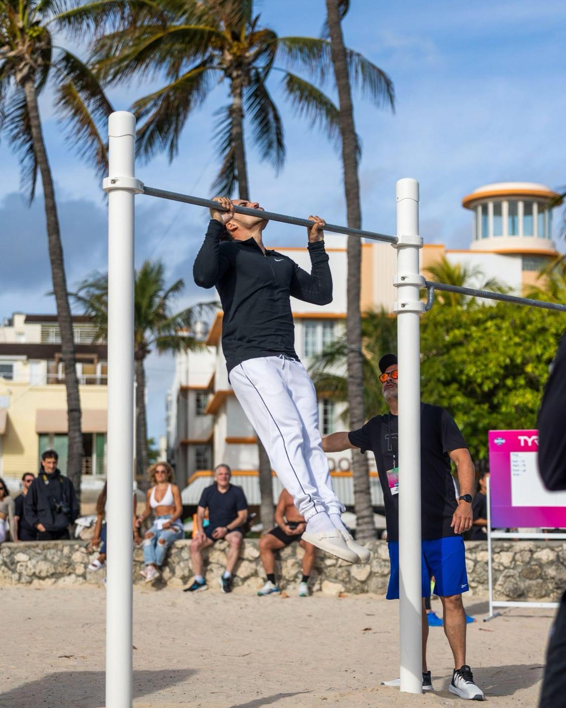 Athlete doing pull-ups under the palms
